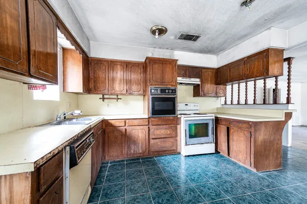 a kitchen with stainless steel appliances granite countertop a stove sink and cabinets
