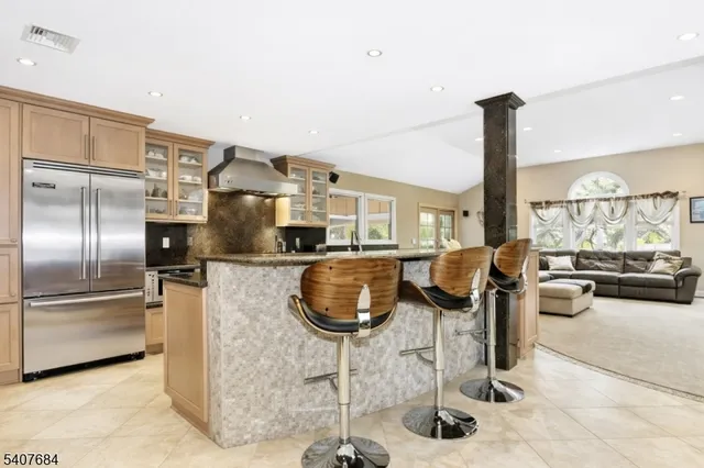 a kitchen with stainless steel appliances granite countertop a sink and a refrigerator