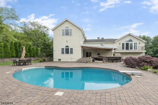 a view of a house with pool and chairs