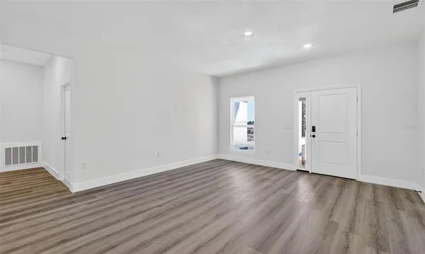 a view of an empty room with wooden floor