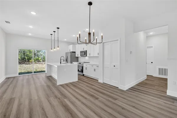 a view of a kitchen with wooden floor and a sink