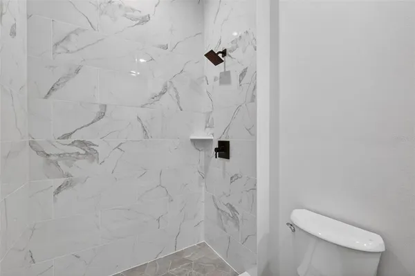 a bathroom with a toilet and a shower