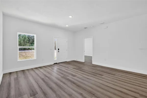 an empty room with wooden floor and window