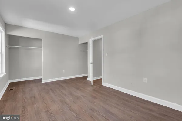 an empty room with wooden floor & window
