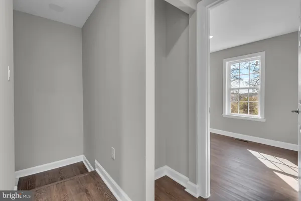 an empty room with wooden floor and a window