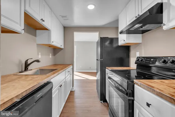 a kitchen with stainless steel appliances granite countertop a sink a stove and a refrigerator