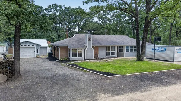 a aerial view of a house with a yard and large tree