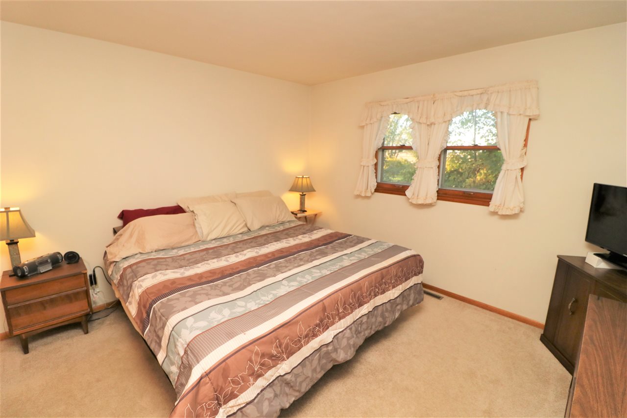 3777 Wheeler Road Cherry Valley, IL 61016 - Photo 8 of 21 a bedroom with a bed and flat tv screen