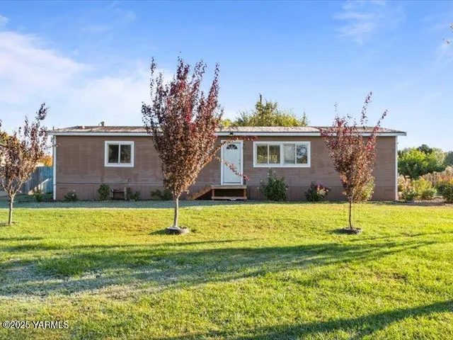 a house with a big yard and large trees