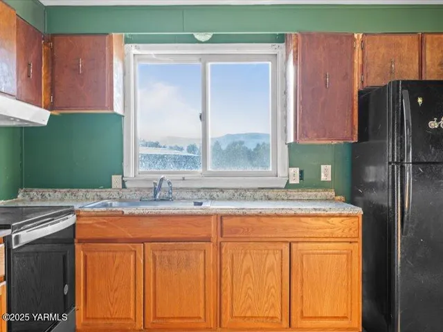 a kitchen with stainless steel appliances granite countertop a stove a sink and a refrigerator