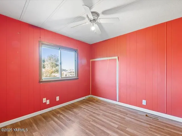 a view of empty room with wooden floor