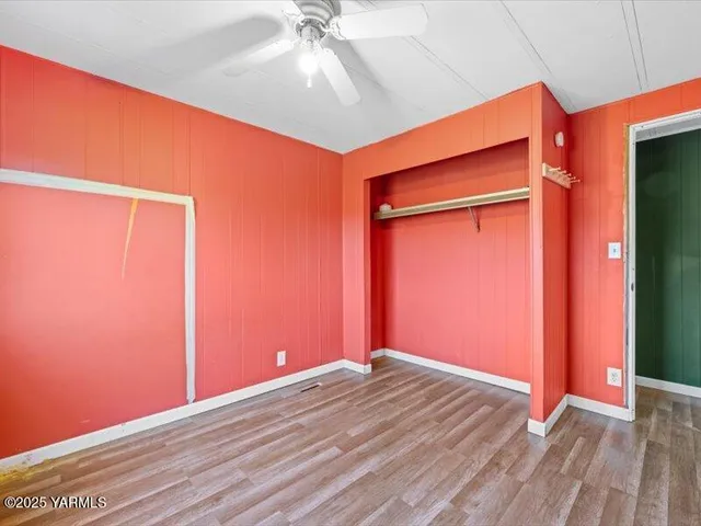 a view of a big room with wooden floor and windows