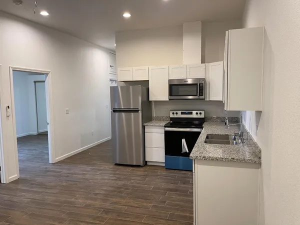 a kitchen with granite countertop a stove and a refrigerator