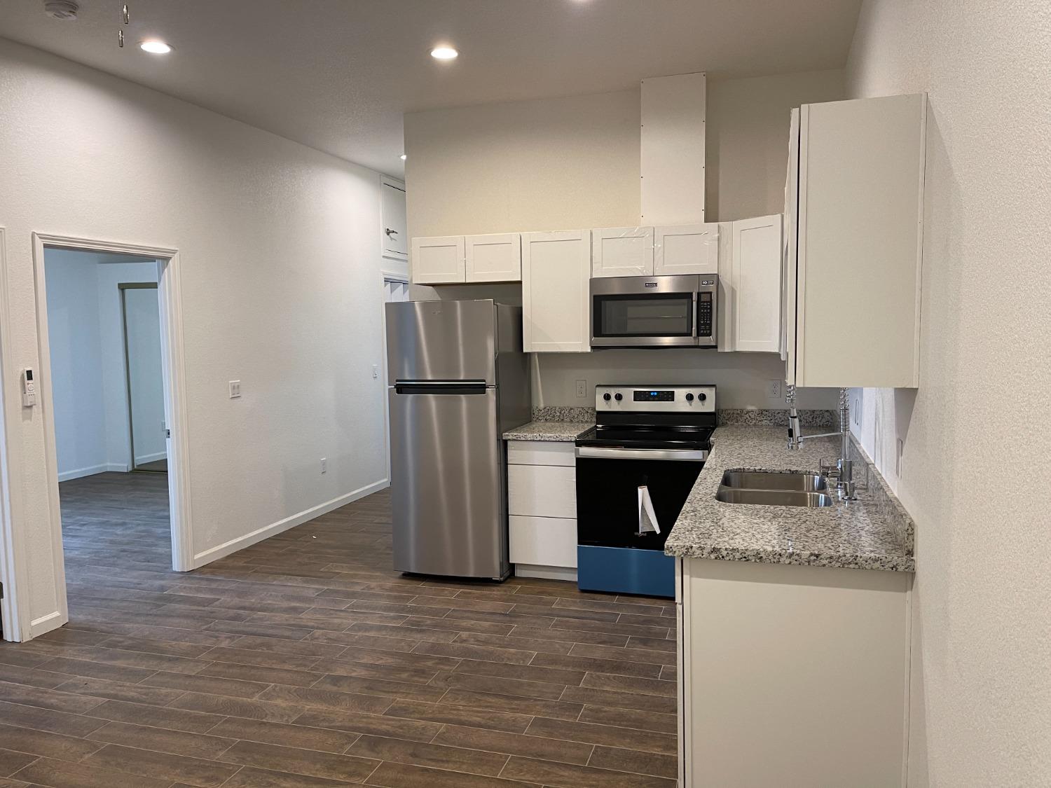 217 5th Street, Unit C Colusa, CA 95932 - Photo 1 of 13 a kitchen with granite countertop a stove and a refrigerator