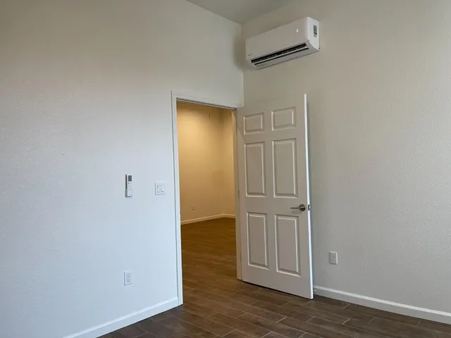 an empty room with wooden floor and closet
