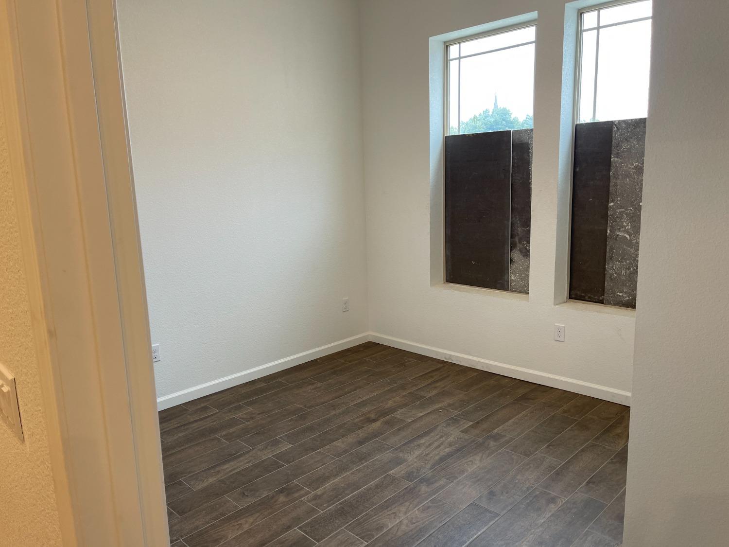 217 5th Street, Unit C Colusa, CA 95932 - Photo 7 of 13 an empty room with wooden floor and windows