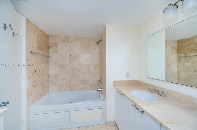 a bathroom with a tub sink and mirror