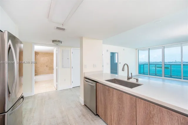 a kitchen with granite countertop a sink and a refrigerator