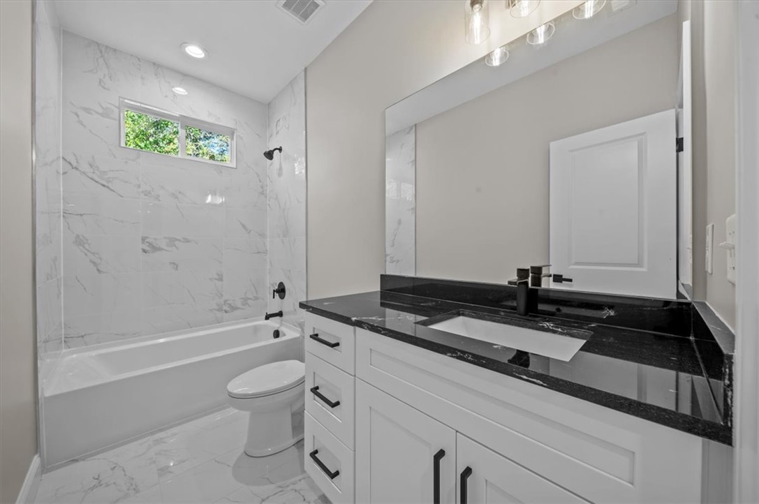 105 Bree Drive Anderson, SC 29621 - Photo 31 of 48 A well-appointed bathroom features a dark vanity with a modern sink, and a combination tub and shower with white tile surround.