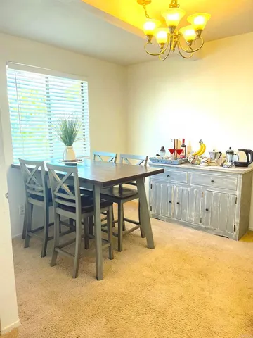 a view of a dining room with furniture and a chandelier