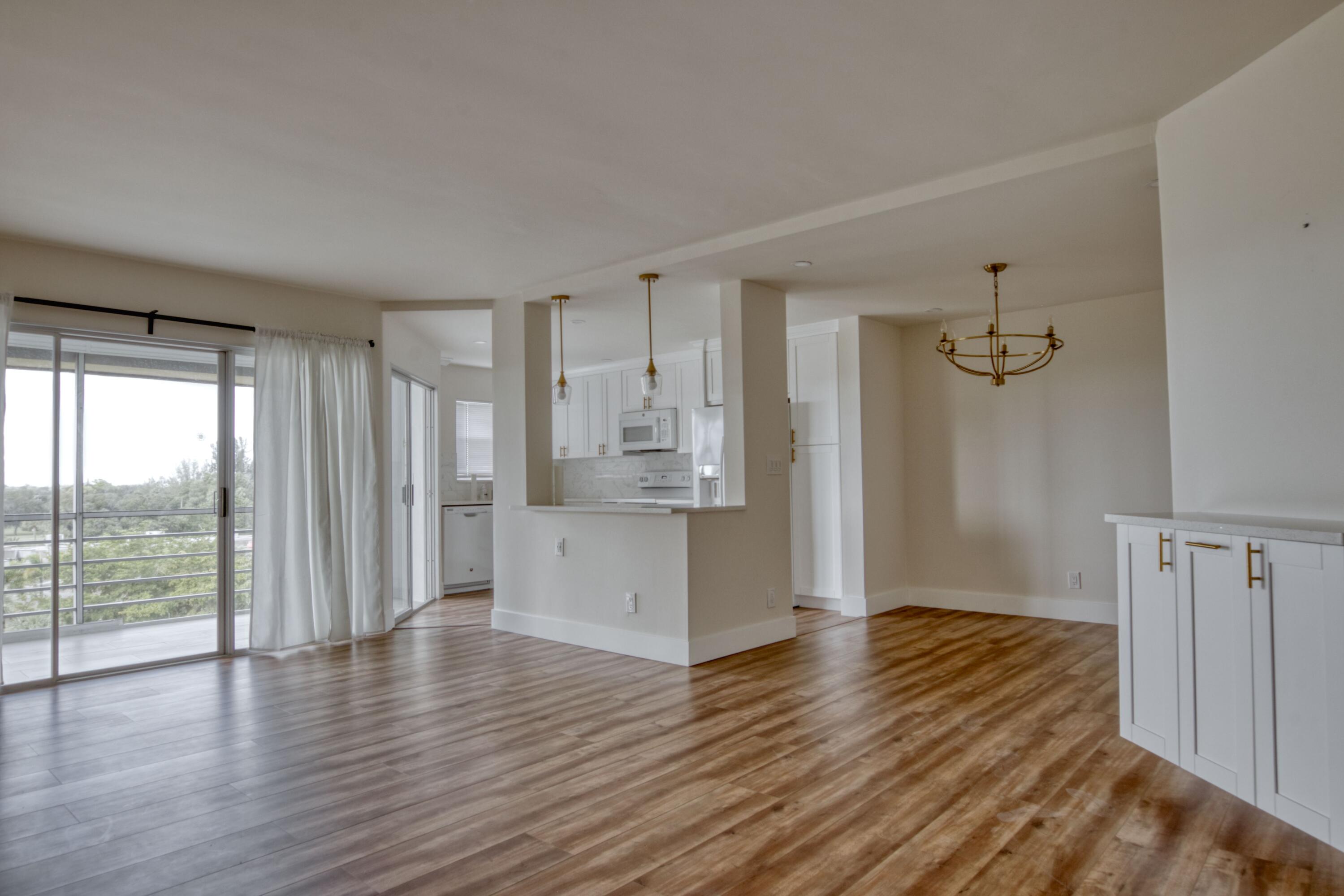 3590 Via Poinciana, Unit 614 Lake Worth, FL 33467 - Photo 4 of 20 a view of a kitchen with wooden floor and a refrigerator