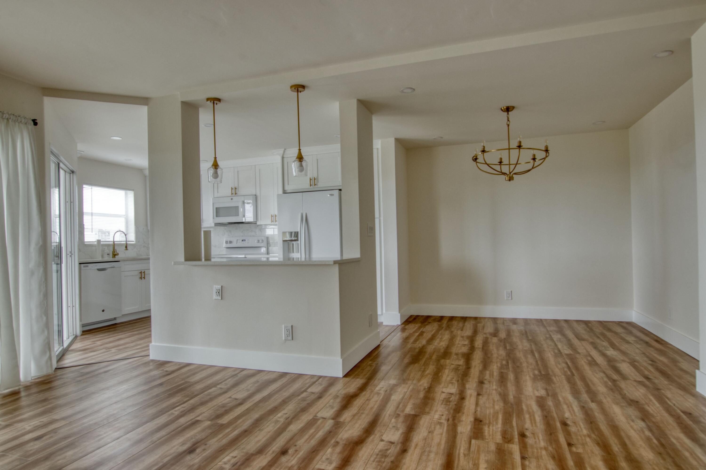 3590 Via Poinciana, Unit 614 Lake Worth, FL 33467 - Photo 5 of 20 a view of kitchen and empty room with wooden floor