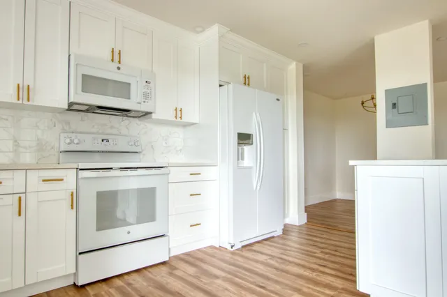 a kitchen with stainless steel appliances white cabinets and a refrigerator