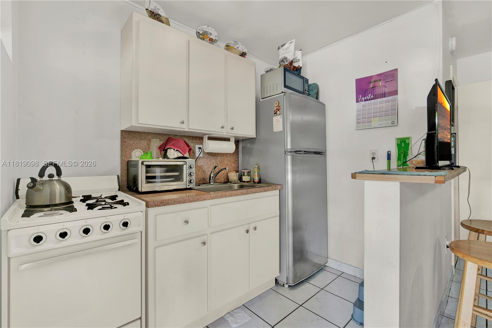 829 Southwest 19th Avenue Miami, FL 33135 - Photo 23 of 54 a kitchen with stainless steel appliances a refrigerator sink and cabinets