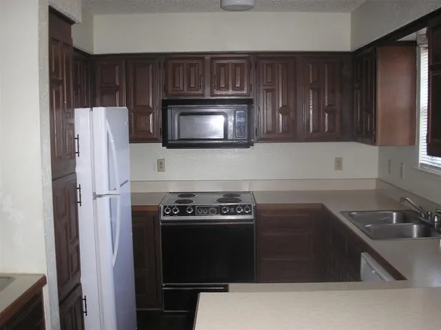 a kitchen with cabinets and steel appliances