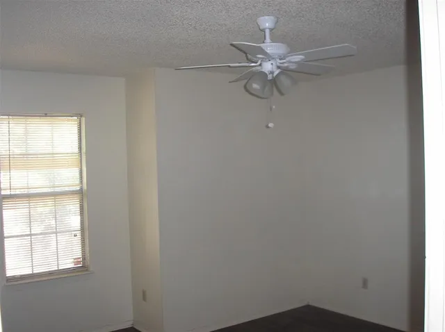 a white wall with window and a chandelier