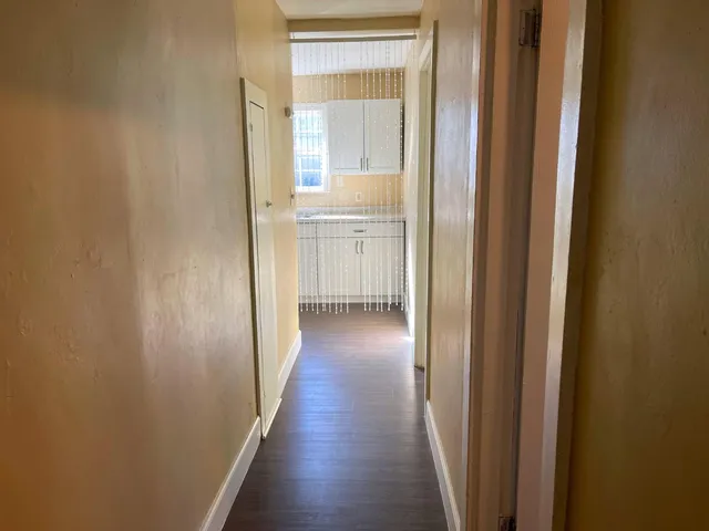 a view of a hallway with wooden floor
