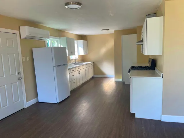 a kitchen with stainless steel appliances a refrigerator sink and wooden floor