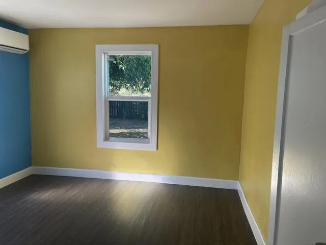 a view of a room with wooden floor and a window