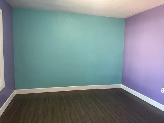 a view of a room with wooden floor and carpet