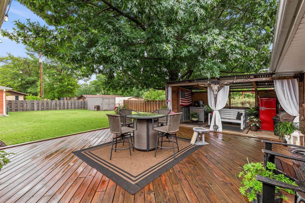 934 North Maple Street Muenster, TX 76252 - Photo 26 of 39 a view of a patio with table and chairs potted plants and wooden fence