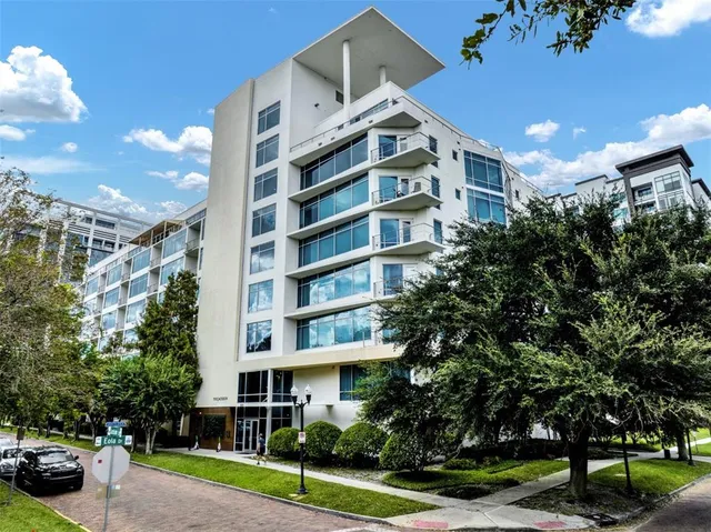 a front view of a building with street view and trees