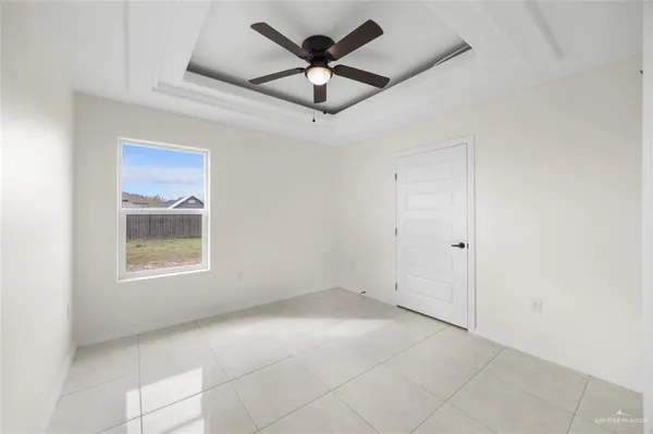 a view of an empty room with a ceiling fan and a window