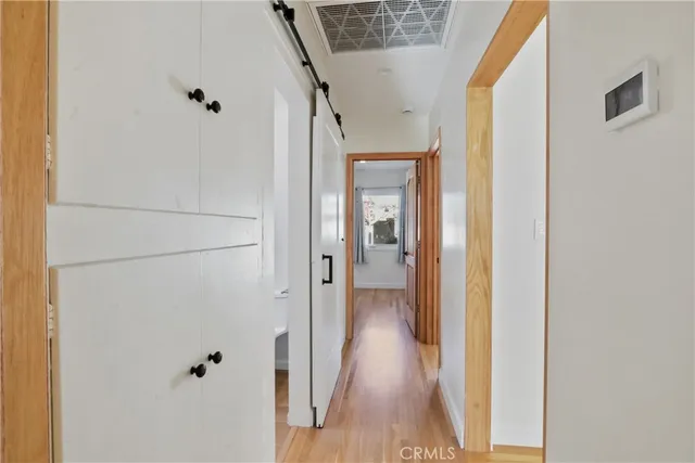 a view of a hallway with wooden floor and staircase