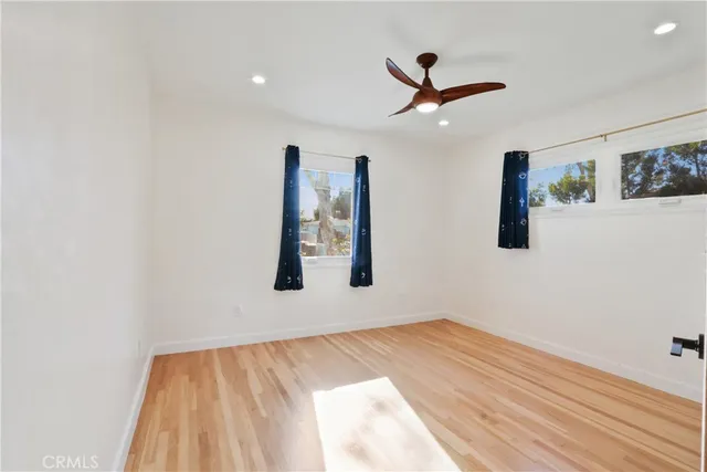 a view of a livingroom with wooden floor and a ceiling fan