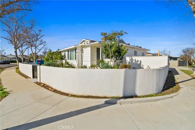 a view of a white house with a yard and large tree