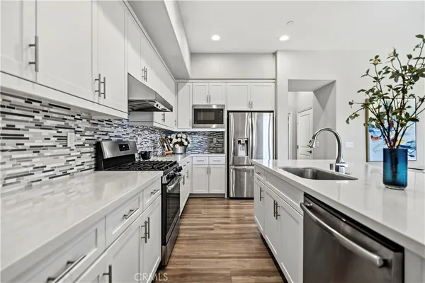 a kitchen with stainless steel appliances granite countertop a sink stove and refrigerator