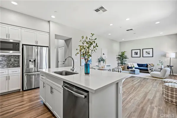 a kitchen with sink refrigerator and microwave