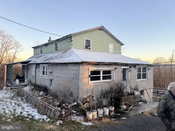 a view of a house with a yard and lawn chairs with wooden fence