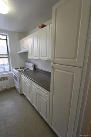 a kitchen with stainless steel appliances a sink a stove a refrigerator a window