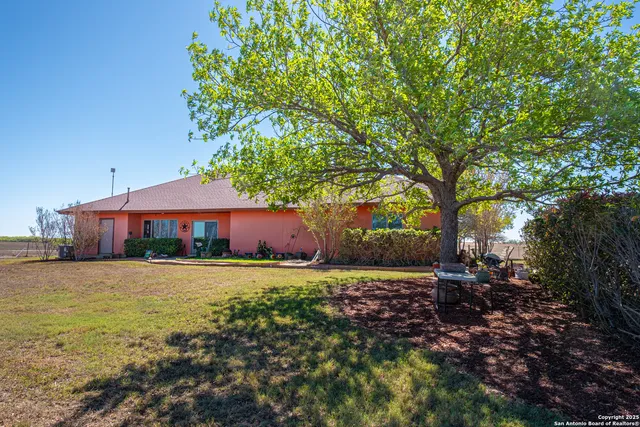 a view of a house with large space and a car parked in front of it