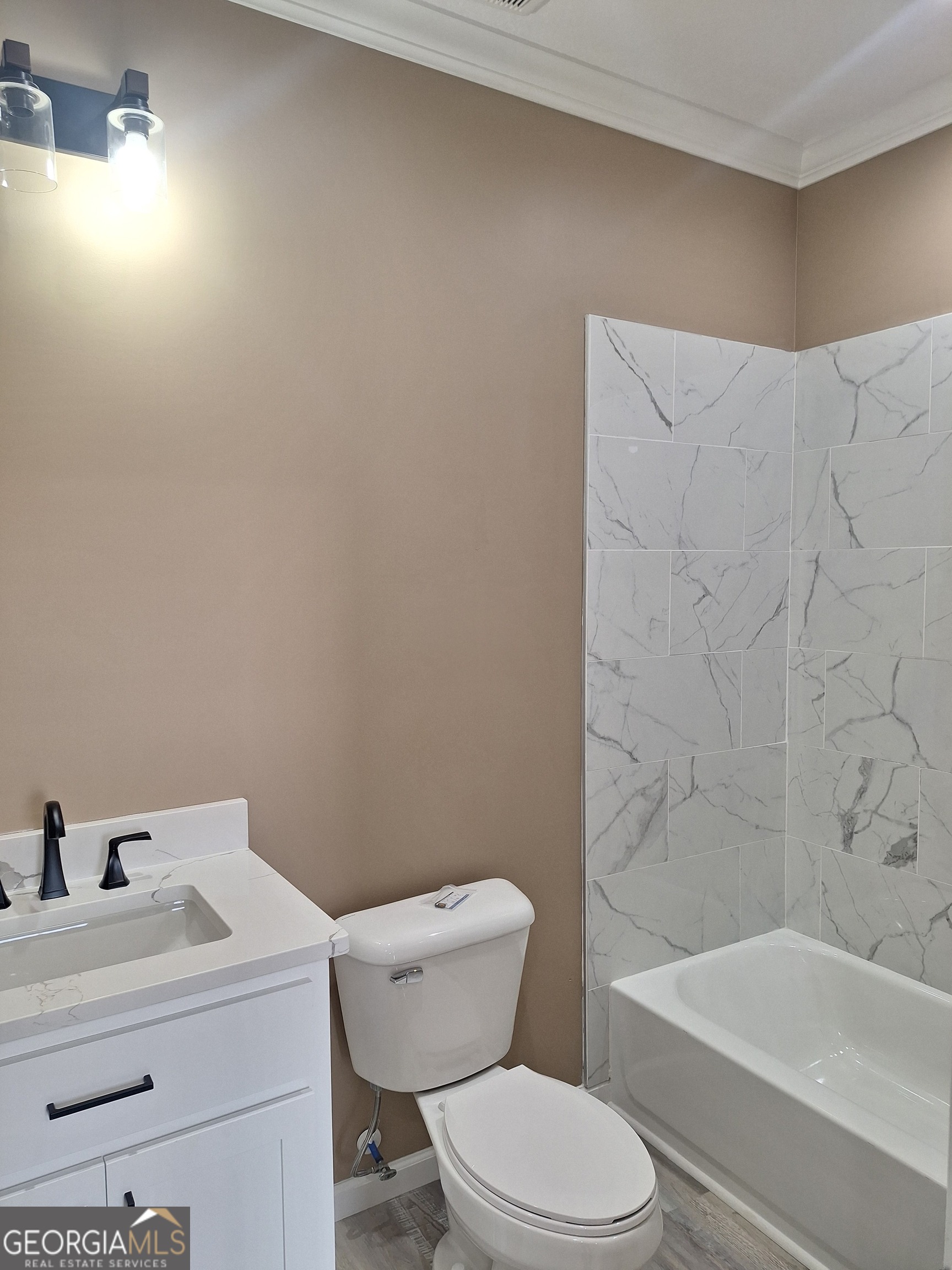 155 Peach Lane Baxley, GA 31513 - Photo 17 of 19 a white toilet sitting next to a bathroom sink and tub