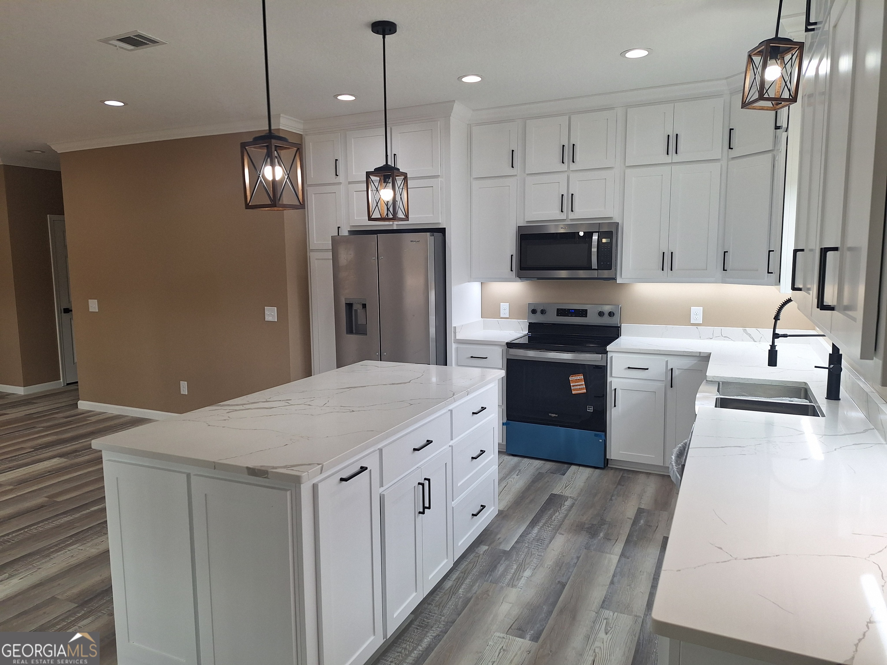 155 Peach Lane Baxley, GA 31513 - Photo 4 of 19 a large kitchen with stainless steel appliances kitchen island a large island in the center
