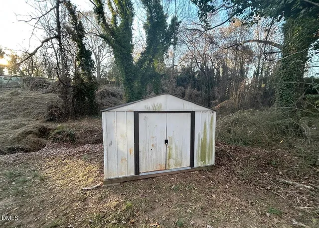 a view of a wooden house with large trees