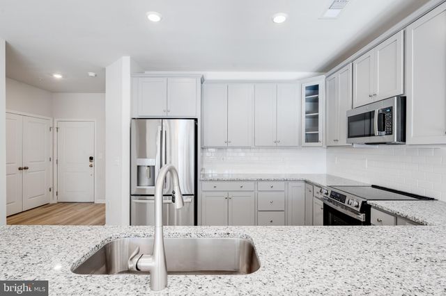 a kitchen with stainless steel appliances granite countertop a sink refrigerator and microwave