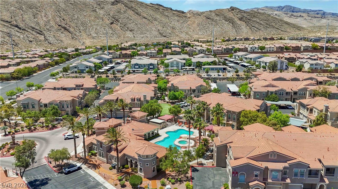 10550 West Alexander Road, Unit 2060 Las Vegas, NV 89129 - Photo 38 of 45 An aerial panorama reveals a vibrant community with terracotta rooftops nestled against a majestic mountain backdrop.